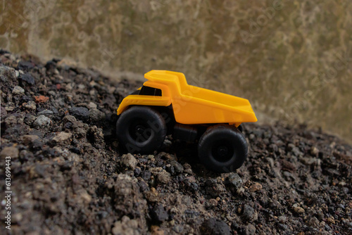 A dump truck on a pile of stones and sand, after some edits.