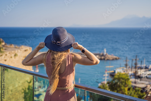Woman tourist in Old town Kaleici in Antalya. Turkiye. Panoramic view of Antalya Old Town port, Taurus mountains and Mediterrranean Sea, Turkey