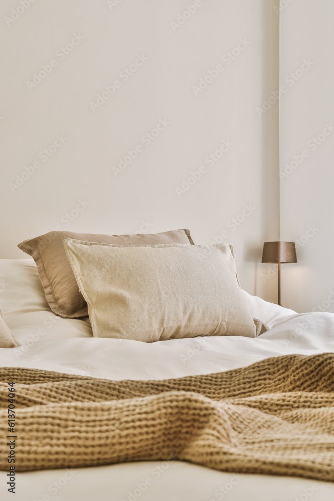 a bed with two pillows and a blanket on the headboard, in front of it is a white wall a bed with two pillows and a blanket on the headboard, in front of it is a white wall