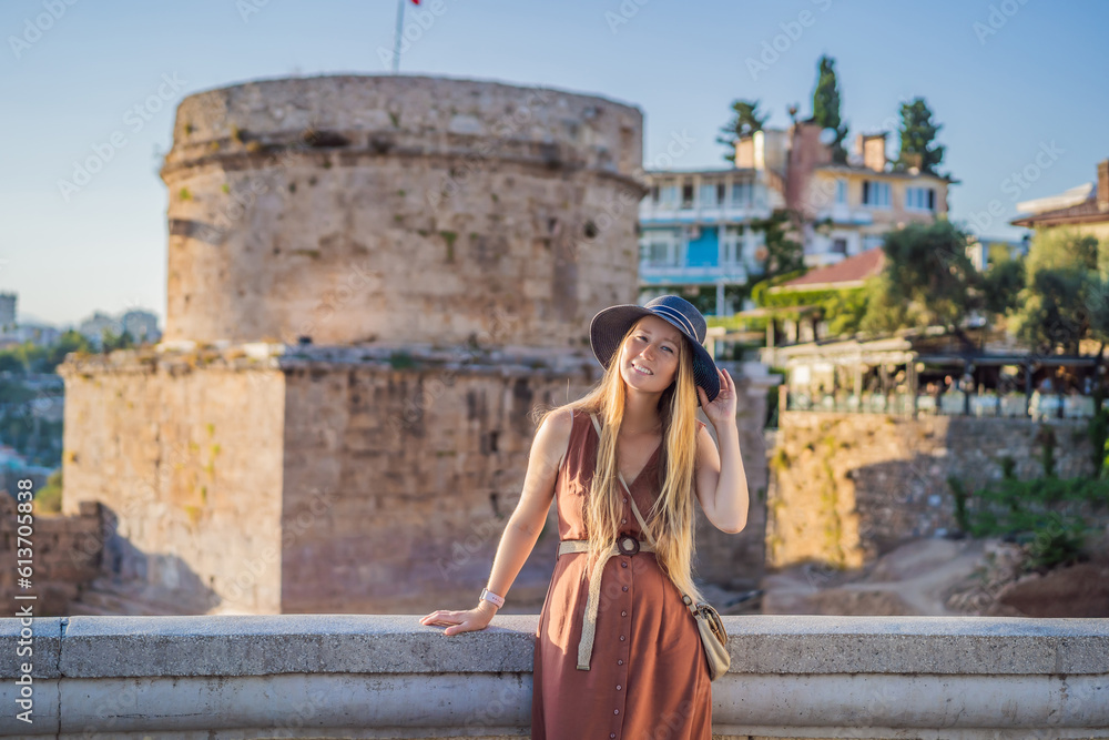 Woman tourist on background of Hidirlik Tower in Antalya against the backdrop of the Mediterranean bay of the ancient Kaleici district, Turkey. Turkiye Woman tourist on background of Hidirlik Tower in Antalya against the backdrop of the Mediterranean bay of the ancient Kaleici district, Turkey. Turkiye