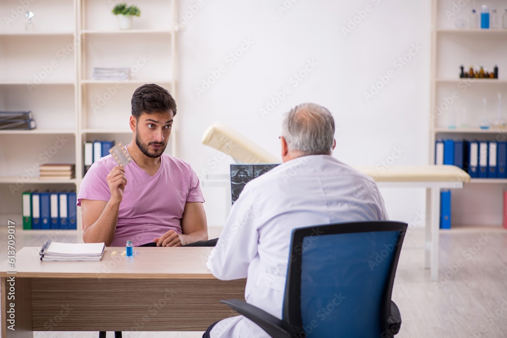 Young male patient visiting old male doctor radiologist Young male patient visiting old male doctor radiologist