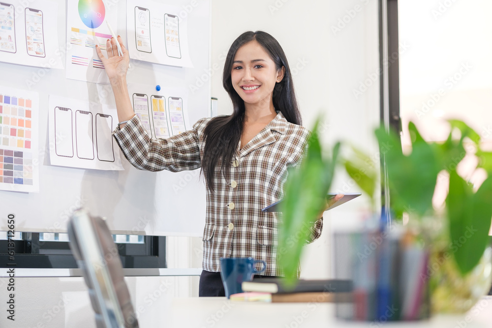 Attractive woman designer creating new website template,  presenting mobile app interface design on whiteboard.
