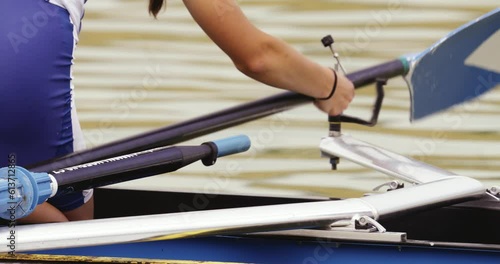 Close-up of the girl's hands fixing the oar to the clamping mechanism on the single scull photo