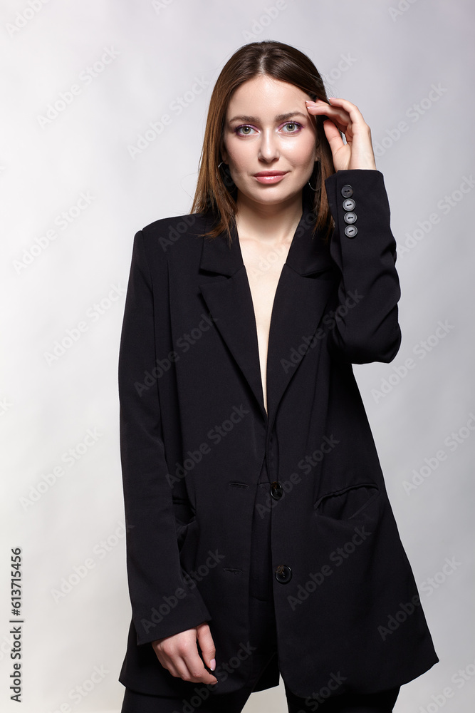Woman in a black jacket on a gray background. Woman in a black jacket on a gray background.