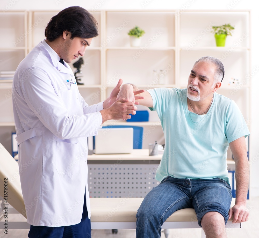 Old man visiting young male doctor Old man visiting young male doctor