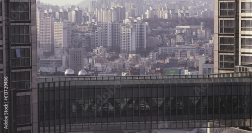 Seoul, Korea Office Worker Walks Through Skyscraper Skywalk Over Modern City Seoul High-Rise Corporate Skyline with Apartments in Background photo