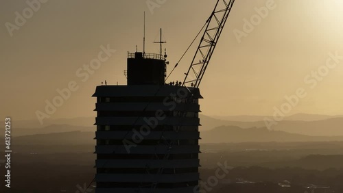 Close Up Telephoto Parallax High Rise Building With Construction Crane In Foreground At Sunset, 4K Drone photo