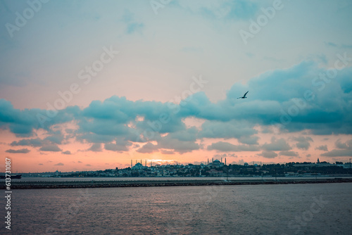 Istanbul at sunset, Turkey. Tourist boat sails on Golden Horn in summer. Beautiful sunny view of Istanbul waterfront with old mosque. Concept of travel, tourism and vacation in Istanbul and Turkey