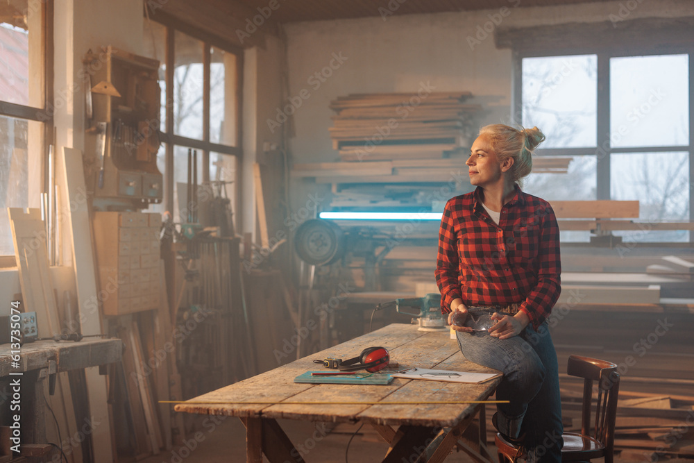 Thoughtful female carpenter in workshop. Thoughtful female carpenter in workshop.
