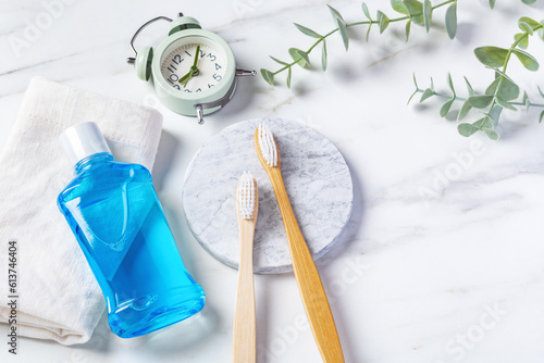 Fotografía Oral health care product, bamboo toothbrush and mouthwash with clock on marble b