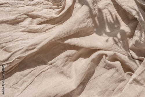 Abstract neutral background, crumpled draped linen fabric texture on sun light with soft shadows, aesthetic sustainable bohemian backdrop, copy space photo