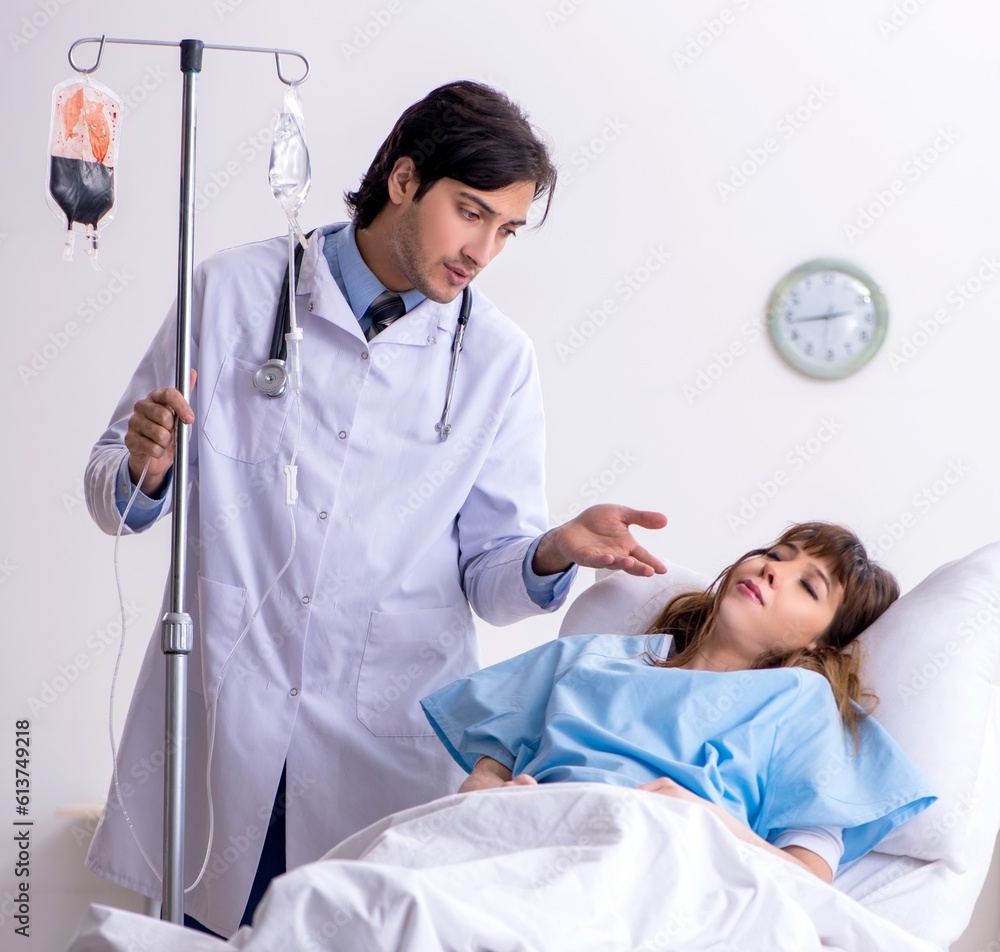 Male doctor visiting female patient in ward Male doctor visiting female patient in ward