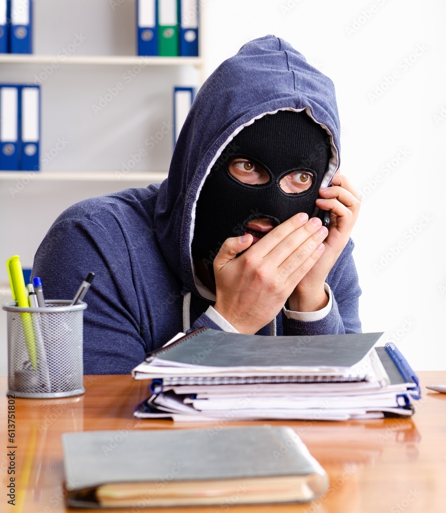 Male thief in balaclava in the office Male thief in balaclava in the office