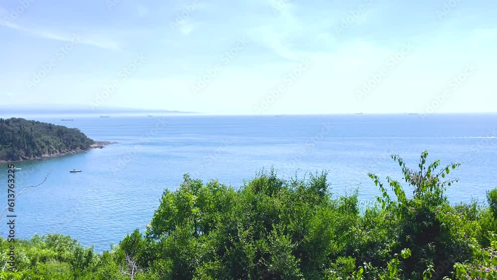 View of the water from a height. Natural background. Seascape. Seascape. The water surface glistens in the sun. Summer, sunny day. Calm sea. Plants, bushes, trees. The water is emerald-colored. View of the water from a height. Natural background. Seascape. Seascape. The water surface glistens in the sun. Summer, sunny day. Calm sea. Plants, bushes, trees. The water is emerald-colored.