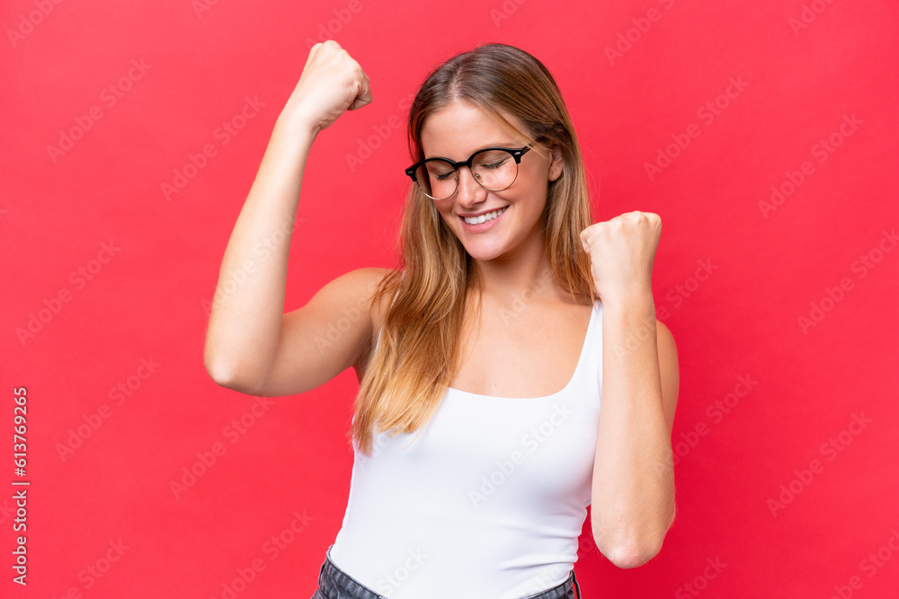 Young beautiful woman isolated on red background celebrating a victory Young beautiful woman isolated on red background celebrating a victory