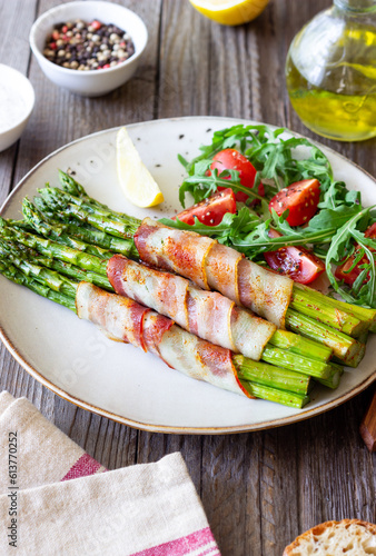 Asparagus baked with bacon and arugula and tomato salad. Healthy eating. Diet.