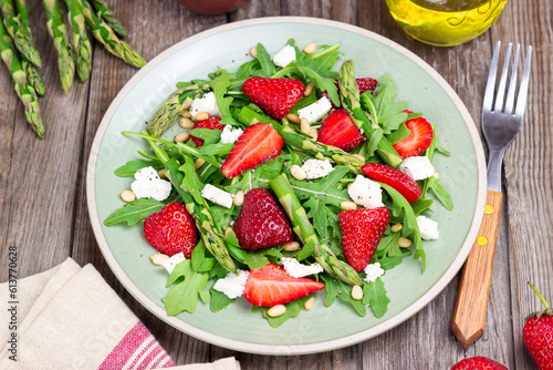Salad with strawberries, asparagus, arugula, white cheese and nuts. Healthy eating. Vegetarian food.