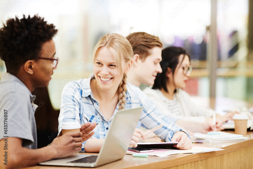 Group of positive multi-ethnic students in casual outfits sitring at one table and chatting in lecture room Group of positive multi-ethnic students in casual outfits sitring at one table and chatting in lecture room