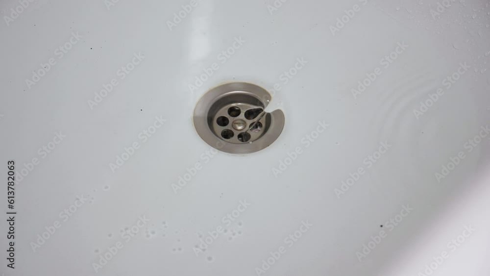 Water flow in the bathroom drain. Slow motion footage of the funnel formation while draining water into the drain from the tub Water flow in the bathroom drain. Slow motion footage of the funnel formation while draining water into the drain from the tub