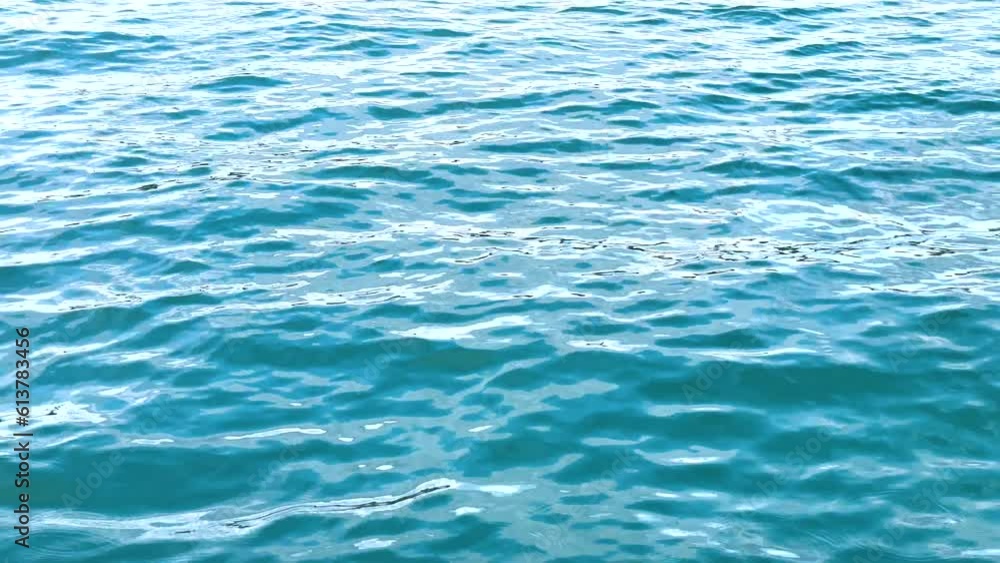 The sea, the water surface. Smooth swaying of the waves. The blue-green surface of the ocean. Light ripples on the surface of the water. Close-up. Natural background. The sea, the water surface. Smooth swaying of the waves. The blue-green surface of the ocean. Light ripples on the surface of the water. Close-up. Natural background.