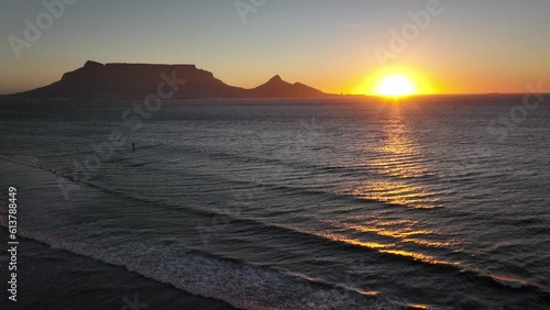 Cape Town South Africa windsurfers sailing windy surf wave Table Mountain drone aerial cinematic Lions Head sunset beach stunning mountain and ocean landscape orange gold sun on horizon forward pan up