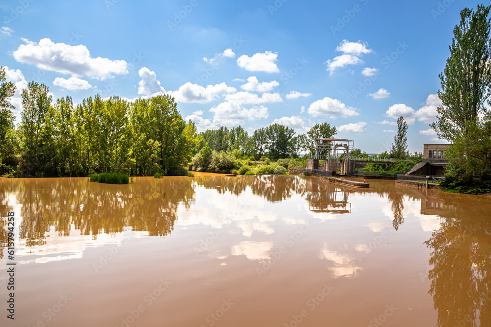 Obraz premium General view of the San Andrés dam of the Canal de Castilla with cloudy water on a sunny day, Herrera de Pisuerga, Palencia, Spain