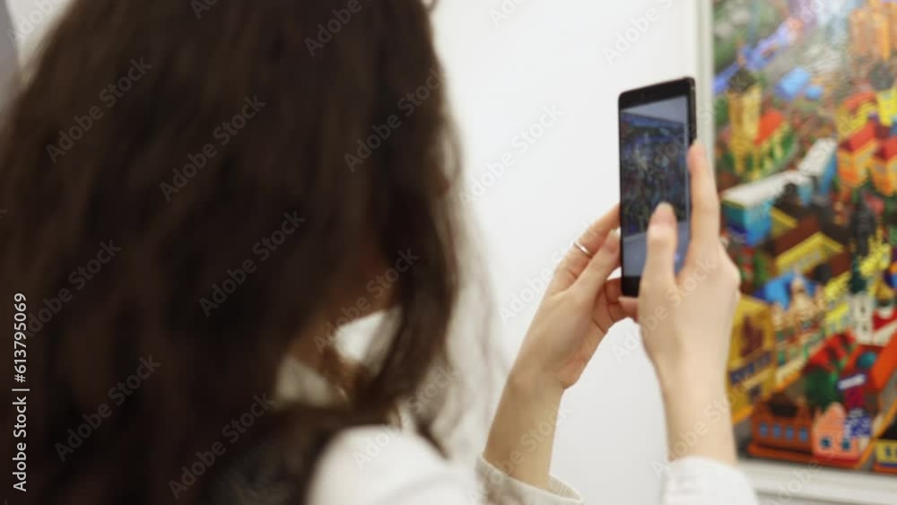 Brunette woman records video on her smartphone. Visit art exhibition Brunette woman records video on her smartphone. Visit art exhibition
