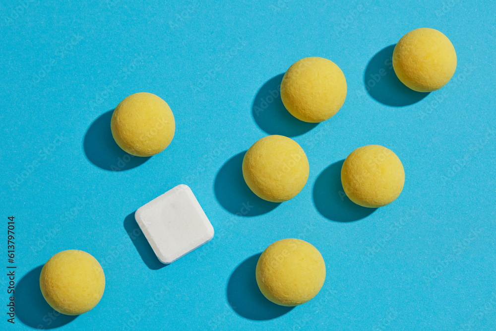 Flat lay creative background for advertising with healthcare and medicine concept. On the blue background, some yellow pills decorated white mint lozenges Flat lay creative background for advertising with healthcare and medicine concept. On the blue background, some yellow pills decorated white mint lozenges