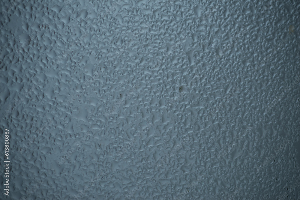 Raindrops on window glass on blur grey background Raindrops on window glass on blur grey background