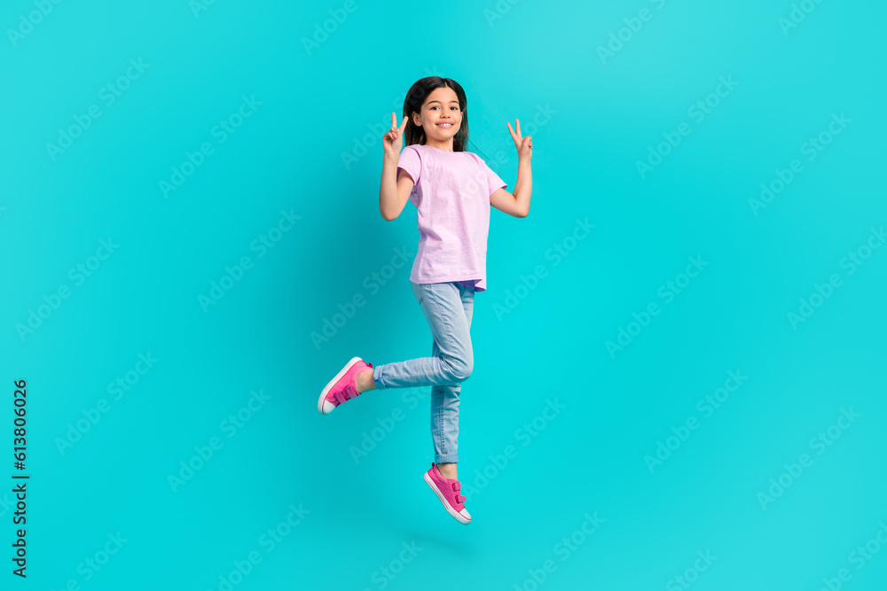 Full size body of schoolgirl pink t-shirt with jeans show double v-sign greetings symbol jumping isolated on aquamarine color background