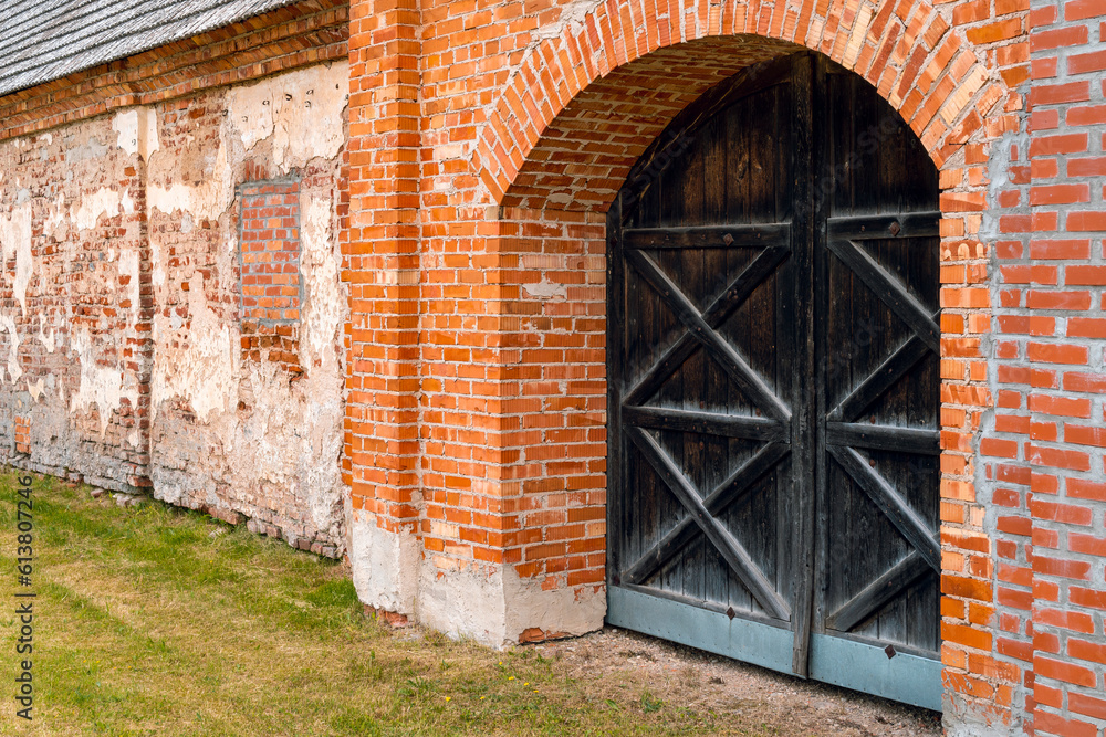 Entrance to medieval old castle. Ancient red brick wall with a wooden doors. Entrance to medieval old castle. Ancient red brick wall with a wooden doors.