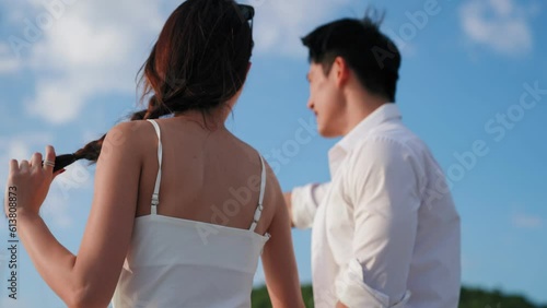 Asian couple sweet love and embracing point to view on luxury yacht while honeymoon trip. Man and woman celebrating anniversary wedding on vacation time, Love concept photo