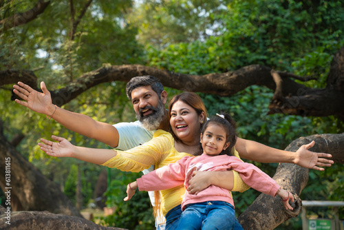 Happy indian couple with his little girl at garden.