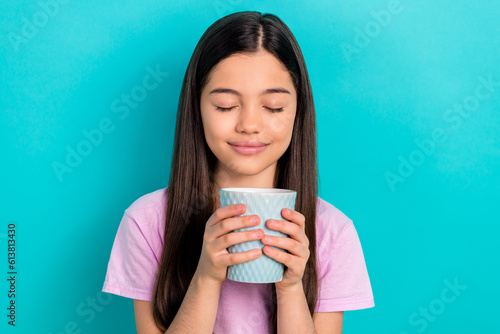 Photo of cheerful dreamy small kid wear pink t-shirt closed eyes enjoying hot beverage isolated turquoise color background