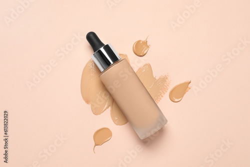 Liquid foundation and swatches on beige background, top view