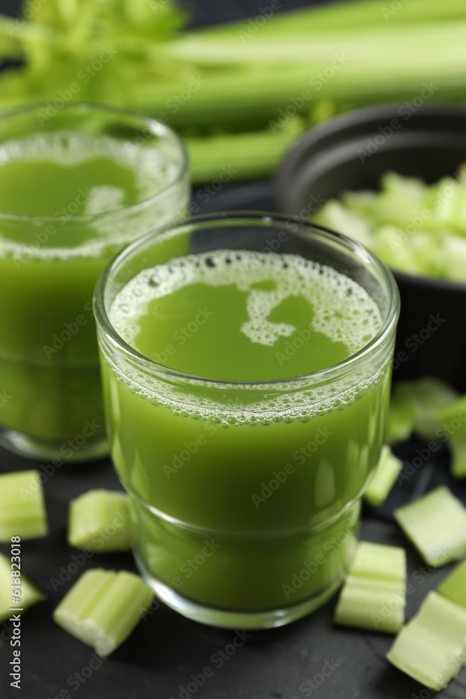 Glasses of delicious celery juice and vegetables on black table, closeup Glasses of delicious celery juice and vegetables on black table, closeup