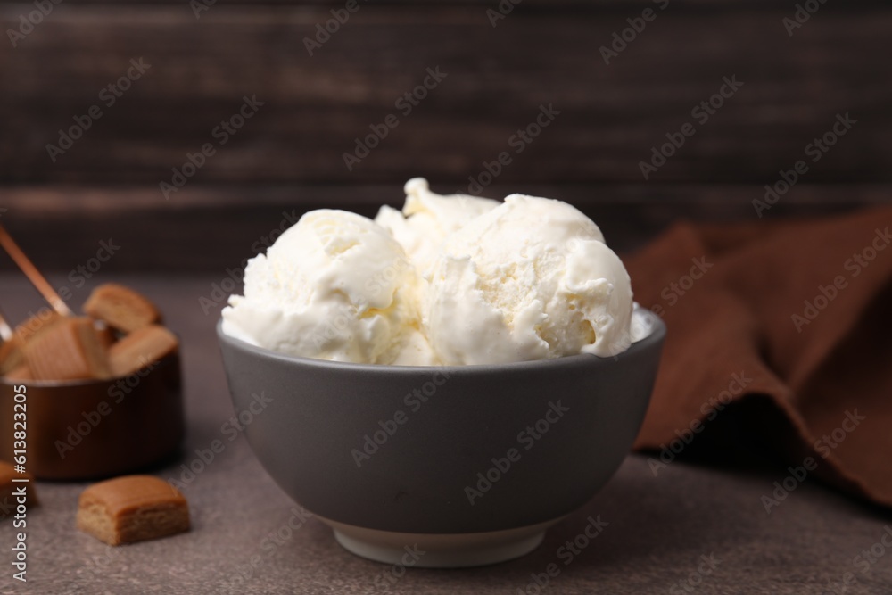 Delicious vanilla ice cream in bowl on textured table Delicious vanilla ice cream in bowl on textured table