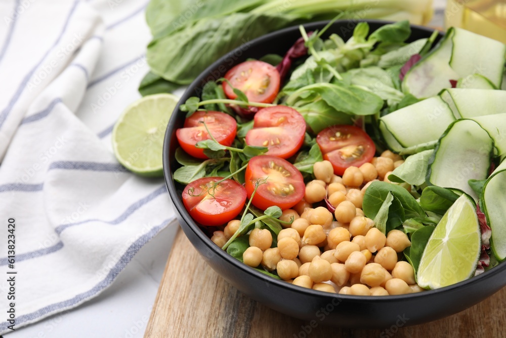 Tasty salad with chickpeas, cherry tomatoes and cucumbers on table, closeup. Space for text