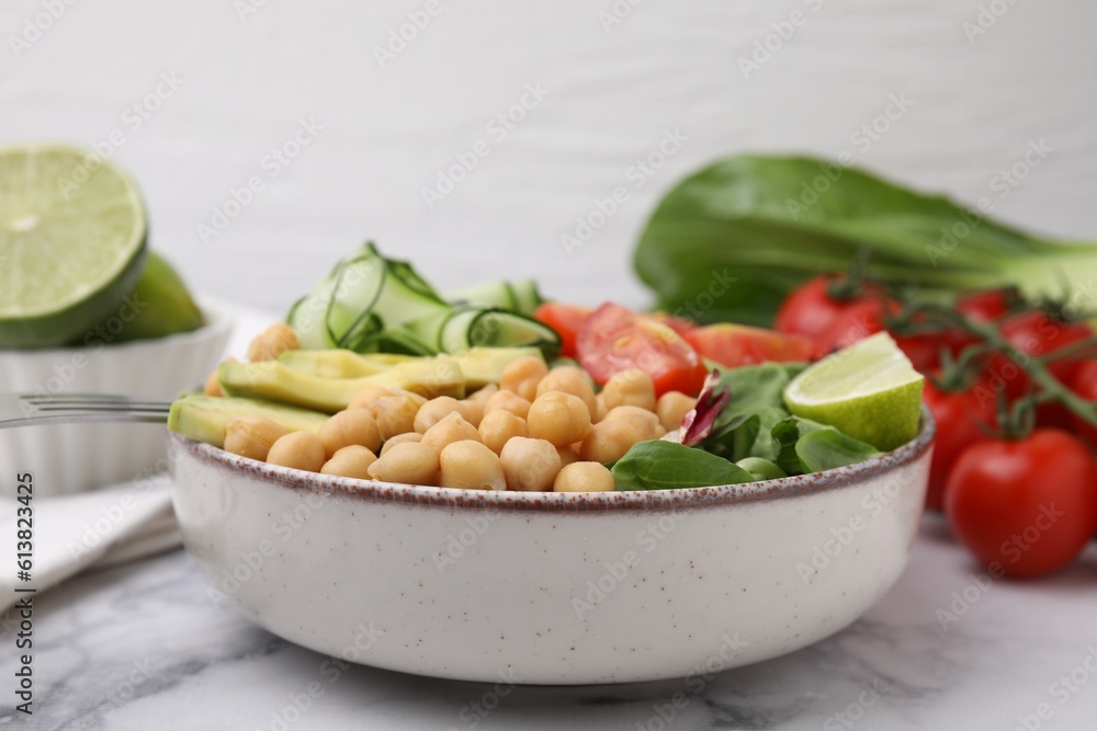 Tasty salad with chickpeas and vegetables on white marble table, closeup Tasty salad with chickpeas and vegetables on white marble table, closeup