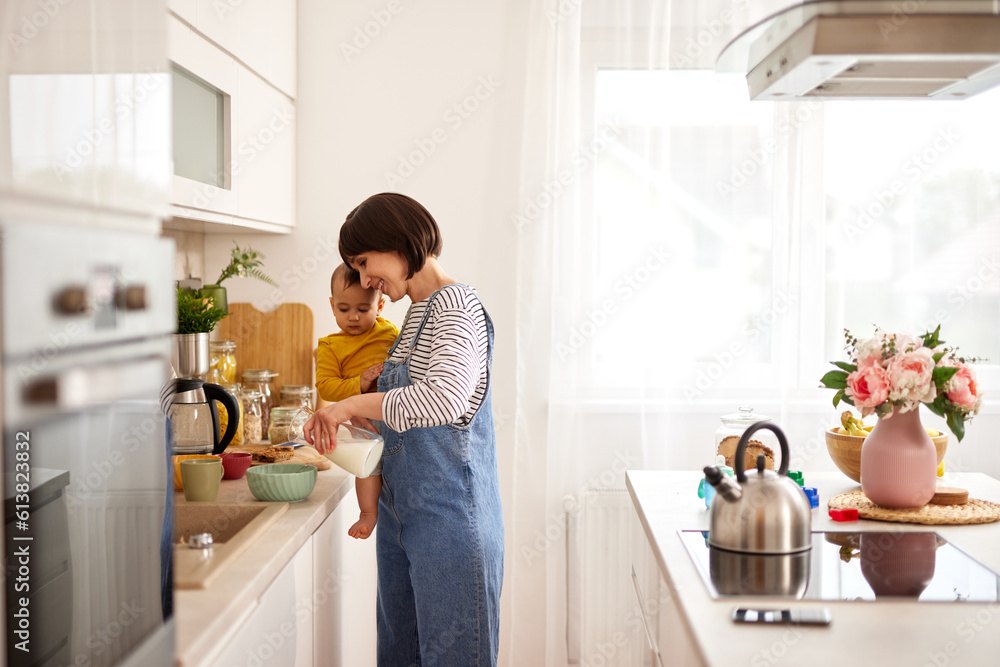Mother and baby boy in the kitchen preparing breakfast