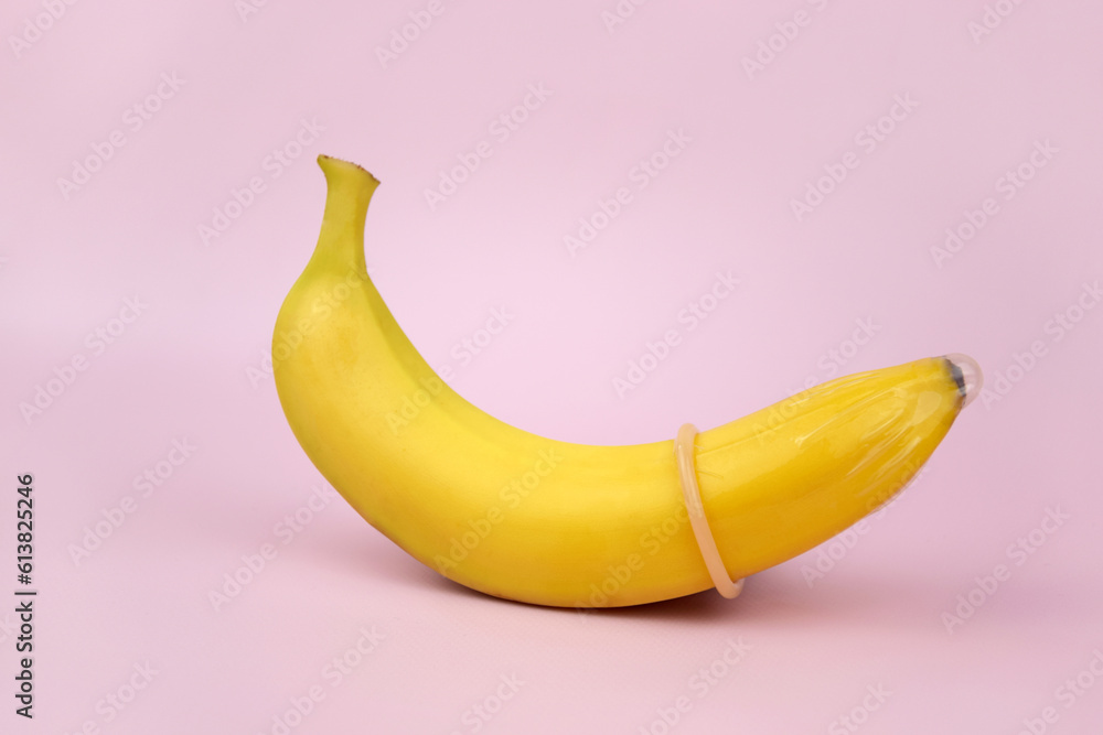Condom and banana on a pink background close-up. Condom and banana on a pink background close-up.