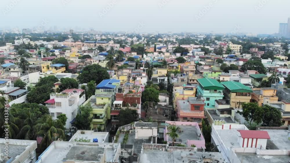 Aerial view of Kolkata's cityscape with rows of buildings, palm trees and pond. Aerial view of Kolkata's cityscape with rows of buildings, palm trees and pond.