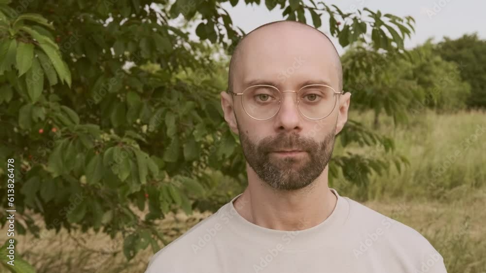 intelligence sad guy, young man in beautiful gold-rimmed glasses, beige t-shirt in garden in nature, pensively looks around, concept of Inner struggles, Emotionally drained, Finding inner strength intelligence sad guy, young man in beautiful gold-rimmed glasses, beige t-shirt in garden in nature, pensively looks around, concept of Inner struggles, Emotionally drained, Finding inner strength