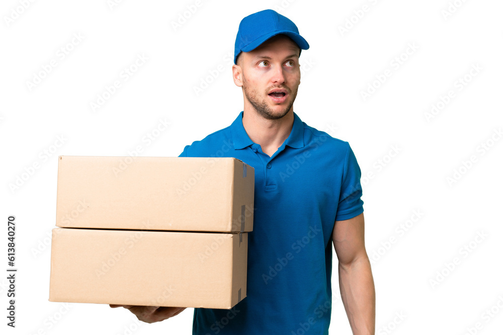 Delivery caucasian man over isolated background looking up and with surprised expression Delivery caucasian man over isolated background looking up and with surprised expression
