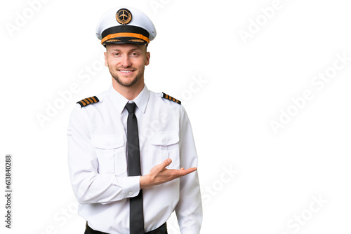 Airplane pilot man over isolated background presenting an idea while looking smiling towards photo