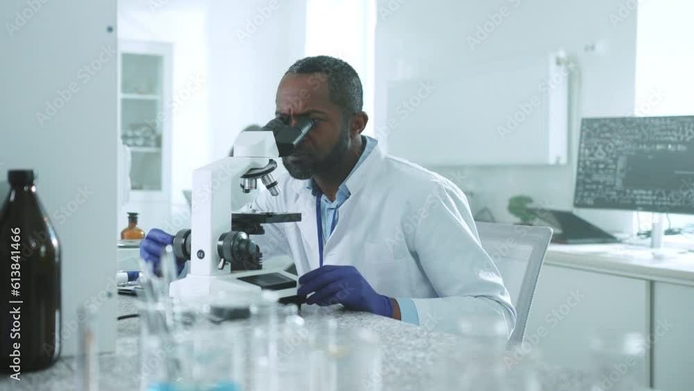 Wonder Handsome African American Scientist Man In Uniform Looked Under A Microscope 