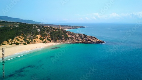 Faro de Camarinal, aerial view of the lighthouse on a cliff at the the wonderful sandy beach with the blue turquoise Atlantic Ocean, Playa Los Alemanes, Andalusia, Spain