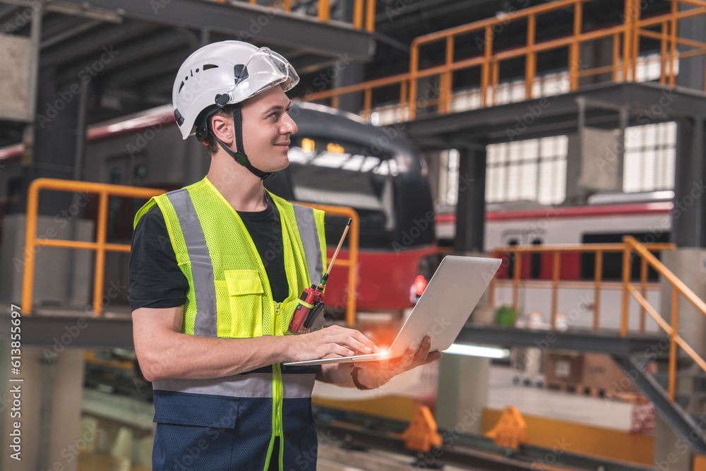 custom made wallpaper toronto digitalCaucasian male technician holding wearing safety helmet uniform holding laptop consulting looking at electric train maintenance schedule in maintenance train station