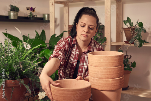 Woman repotting and taking care of houseplants indoors. © astrosystem
