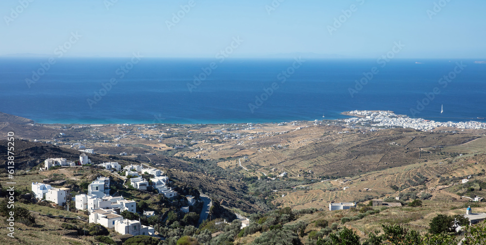 Tinos island, Cyclades Greece. Rocky land and white houses, blue sea and sky
